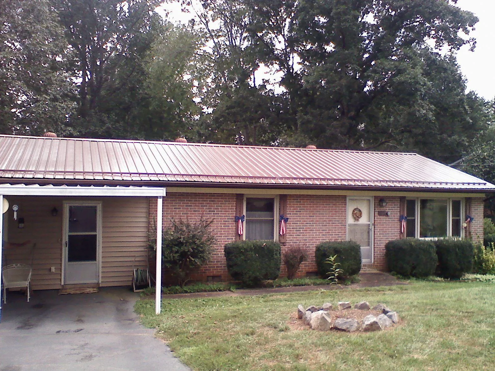 Bronze metal roof and carport on a brick ranch home — Roof Repair work by our crew in Cheltenham